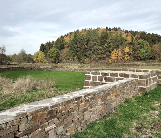 Ruinen des Kleinkastells Urft, umgeben von grüner Wiese und herbstlichem Wald. Der Himmel ist bewölkt., © Sweco GmbH Ruinen des Kleinkastells Urft, umgeben von grüner Wiese und herbstlichem Wald. Der Himmel ist bewölkt., © Sweco GmbH