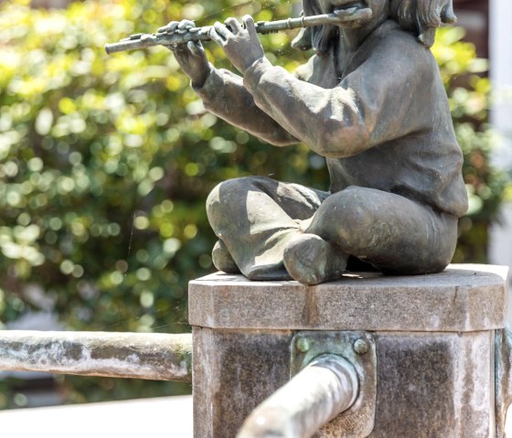 Flute player Healing stone fountain, © Eifel Tourismus GmbH, AR-shapefruit AG Flute player Healing stone fountain, © Eifel Tourismus GmbH, AR-shapefruit AG