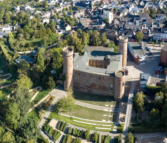 Aerial view of Zülpich Castle with park on the moat and view of the town center. The castle is surrounded by green areas and paths., © Paul Meixner Aerial view of Zülpich Castle with park on the moat and view of the town center. The castle is surrounded by green areas and paths., © Paul Meixner