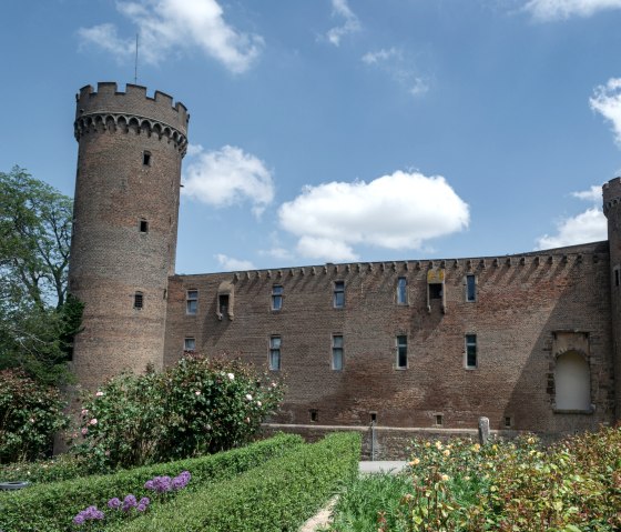 Die Landesburg Zülpich mit zwei runden Türmen und einem gepflegten Garten im Vordergrund unter blauem Himmel., © Nordeifel Tourismus GmbH Die Landesburg Zülpich mit zwei runden Türmen und einem gepflegten Garten im Vordergrund unter blauem Himmel., © Nordeifel Tourismus GmbH