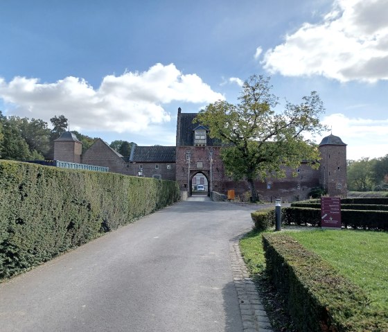 Zufahrtsweg zur Burg Heimerzheim, ges&auml;umt von gepflegten Hecken. Im Hintergrund die historische Burg mit T&uuml;rmen und einem gro&szlig;en Tor., &copy; Sweco GmbH